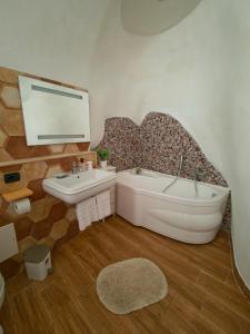 a bathroom with a bath tub and a sink at Dammuso Nuzzarè in Syracuse