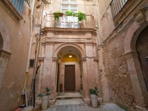 an alley in an old building with potted plants at Dammuso Nuzzarè in Syracuse