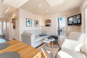 a living room with white furniture and a tv at Snowbird in Lübeck +31 photos