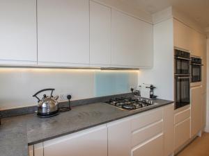 a kitchen with white cabinets and a tea kettle on the counter at 7 Thurlestone Rock in Kingsbridge