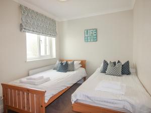 two twin beds in a room with a window at 7 Thurlestone Rock in Kingsbridge +20 photos