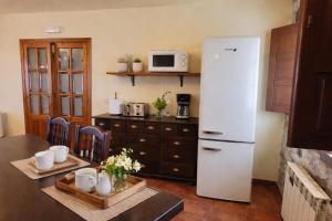 a kitchen with a white refrigerator and a table at Casa Pelayin in Cue