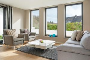 a living room with a couch and chairs and windows at Gemütliches Ferienhaus in Scharbeutz +42 photos