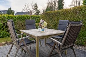 a wooden table and four chairs on a patio at Gemütliches Ferienhaus in Scharbeutz