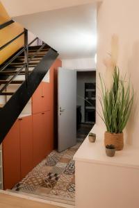 a hallway with red cabinets and a staircase with plants at Le Saint Regis - Hyper centre. in Le Puy-en-Velay