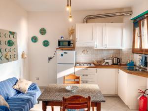 a small kitchen with a blue couch and a table at Il Nido sullo Scoglio in Bonassola