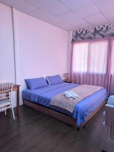 a bedroom with a bed with blue pillows and a window at La Casa De Eros in Ayampe