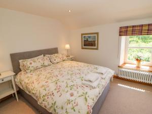 a bedroom with a bed with a floral bedspread at Wayside Farm in Richmond