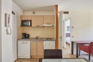a small kitchen with a sink and a microwave at Appart'hôtel Odalys City - Antibes Olympe in Antibes +95 photos
