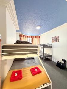 ein Schlafzimmer mit zwei Etagenbetten mit roten Handtüchern in der Unterkunft Backpackers Blackpool Hotel & Suites in Blackpool