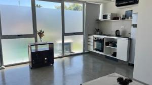 a kitchen with white appliances and large windows at DEPARTAMENTO moderno en Martinez cerca de clinicas y oficinas con WIFI y AA ideal para parejas y o viajes de trabajo in Martínez