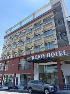 a car parked in front of a hotel at PureJoy Hotel Langkawi in Kuah