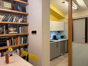 eine Küche mit einem Tisch und einem Bücherregal mit Büchern in der Unterkunft Casa 65 in Pontedera + 10 Fotos