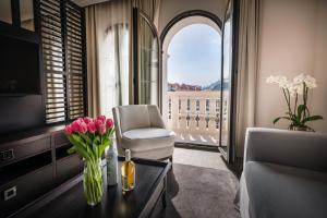 a living room with a vase of flowers on a table at Hotel Moskva in Budva +47 photos