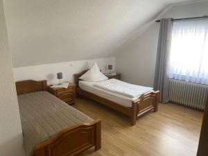 a small bedroom with two beds and a window at Gästehaus Wildfein in Wilnsdorf