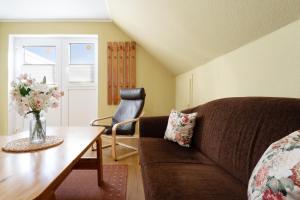 a living room with a couch and a table at Dorfstraße 28 Seerose in Klausdorf