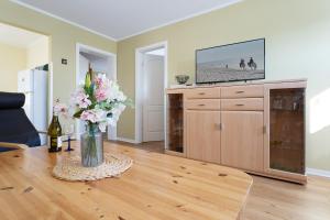 a living room with a vase of flowers on a table at Dorfstraße 28 Seerose in Klausdorf
