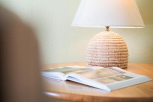 an open book on a table next to a lamp at Dorfstraße 28 Seerose in Klausdorf