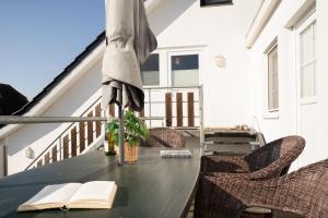 a table with an umbrella and an open book on a balcony at Dorfstraße 28 Seerose in Klausdorf +28 photos