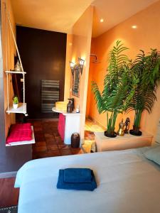a bedroom with a bed and a potted plant at Le Cocon Des Arcades - Central, charmant balcon - in Limoux