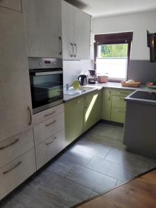 a kitchen with white and green cabinets and a window at Ferienwohnung Heider in Dippoldiswalde