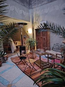 a living room with a table and chairs and plants at L'îlot in Sidi Ifni
