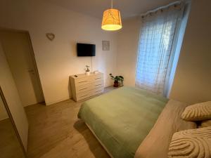 ein Schlafzimmer mit einem Bett, einer Kommode und einem Fernseher in der Unterkunft Gerenzone Bridge-Air conditioning in Lecco
