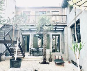 a patio with a table and a palm tree in front of a building at Respiro in Paris
