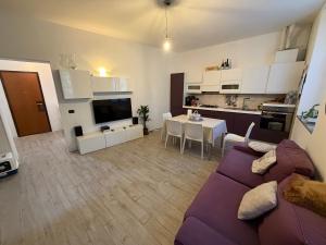 ein Wohnzimmer mit einem lila Sofa und eine Küche in der Unterkunft Gerenzone Bridge-Air conditioning in Lecco
