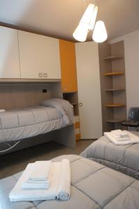 a room with two beds and a table with towels at Mandrolisai Rooms in Samughèo +21 photos