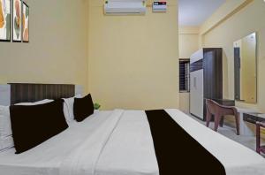 a bedroom with a large white bed with black pillows at Hotel Sri Krishna palace in Kātni
