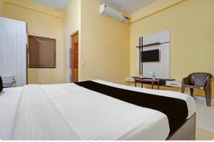 a bedroom with a large white bed and a chair at Hotel Sri Krishna palace in Kātni