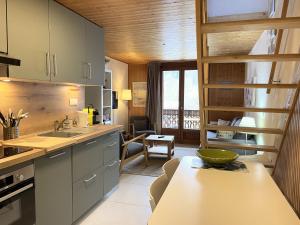 a kitchen with a counter and a dining room at Between lake en ski resort in Thollon