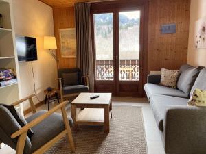 a living room with a couch and a table at Between lake en ski resort in Thollon