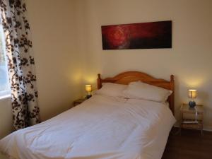BargrennanにあるCulsharg Cottageのベッドルーム1室(白いシーツとランプ2つ付)