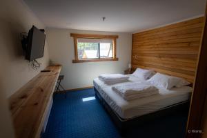 a bedroom with a bed with a wooden headboard and a television at Las Bravas Lodge in Las Trancas