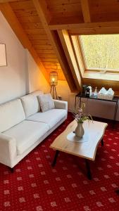 a living room with a white couch and a table at Landhaus Lauble in Hornberg