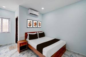 a bedroom with a bed with a white and black blanket at Super Hotel O MM Stay & Luxury Rooms in Hyderabad