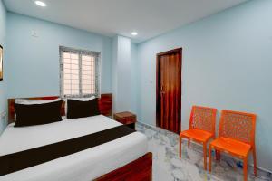 a bedroom with a bed and two orange chairs at Super Hotel O MM Stay & Luxury Rooms in Hyderabad