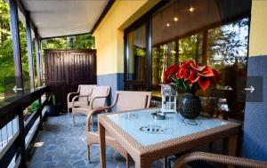 a table with a vase of flowers on a balcony at Apartament Kalinderu K3 Busteni in Buşteni