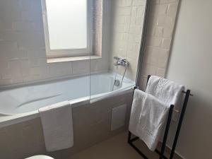 a bathroom with a tub and a shower with towels at IDDA Concept 4 in Târgu-Mureş +24 photos