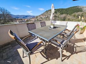 a table and chairs on a balcony with a view at Apartment Paz by Interhome in Donji Proložac +19 photos