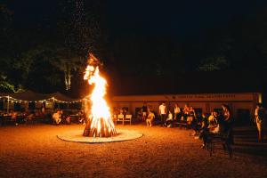a fire pit with people sitting around it at night at Arsenal Park Transilvania in Orăştie +62 photos