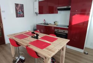 a wooden table in a kitchen with red cabinets at le cocon de Saeby in Dreslincourt