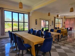 a conference room with tables and chairs and windows at Kasbah Ntifa in Ouzoud
