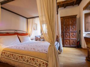 a bedroom with a canopy bed and a wooden door at Apartment Maghinardo by Interhome in Palazzuolo sul Senio