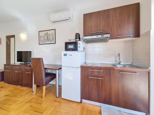 a kitchen with a white refrigerator and a table at Studio Rilić-2 by Interhome in Zaostrog