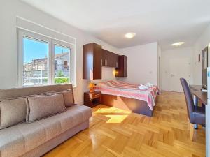 a living room with a couch and a bed at Studio Rilić-2 by Interhome in Zaostrog