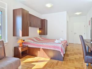 a bedroom with a bed and a desk and a chair at Studio Rilić-2 by Interhome in Zaostrog