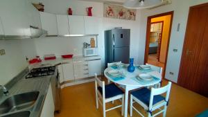 a kitchen with a table and chairs and a refrigerator at BILOCALE IN PIAZZA A NUMANA VISTA MARE BELLISSIMA - cod 485 in Numana